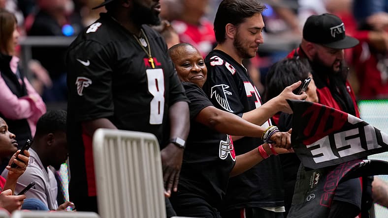 Falcons fans in 2022 at Mercedes-Benz Stadium, one wearing a Kyle Pitts jersey