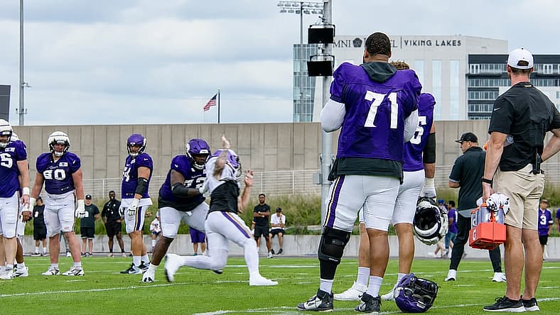Christian Darrisaw stands near the sideline during Vikings training camp.