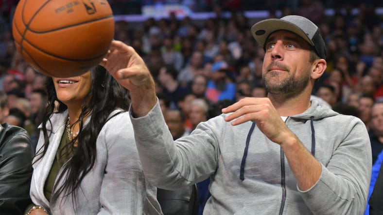 Green Bay Packers quarterback Aaron Rodgers throws the ball back during an NBA game.