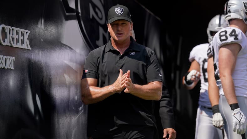 Jon Gruden walks onto the field before a Raiders-49ers game in 2021.