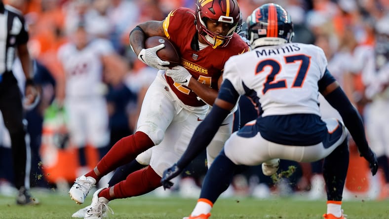 Antonio Gibson runs with ball against Broncos at Empower Field.