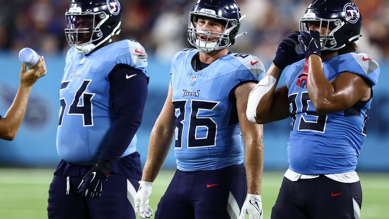 Titans players Stilianos, Odukoya, and Christian regroup on the sideline.