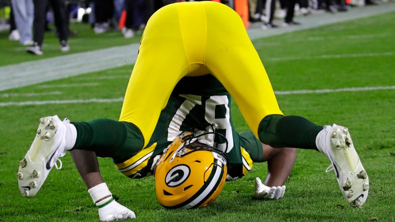 Romeo Doubs lands awkwardly after being interfered with by a 49ers defender.