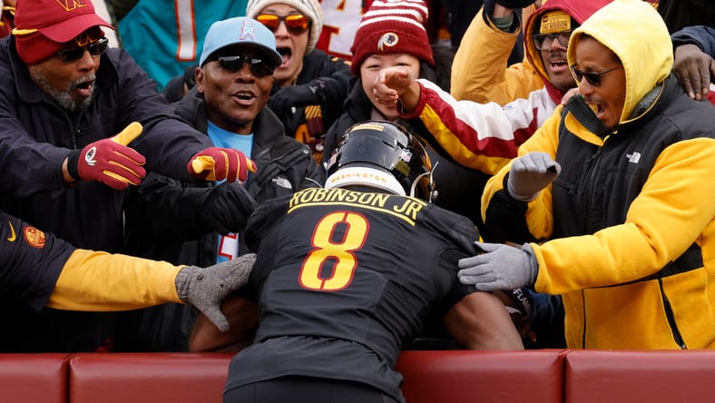 Brian Robinson Jr. celebrates with fans after Titans touchdown. Robinson entered the Vikings rumor mill in the summer of 2025. 