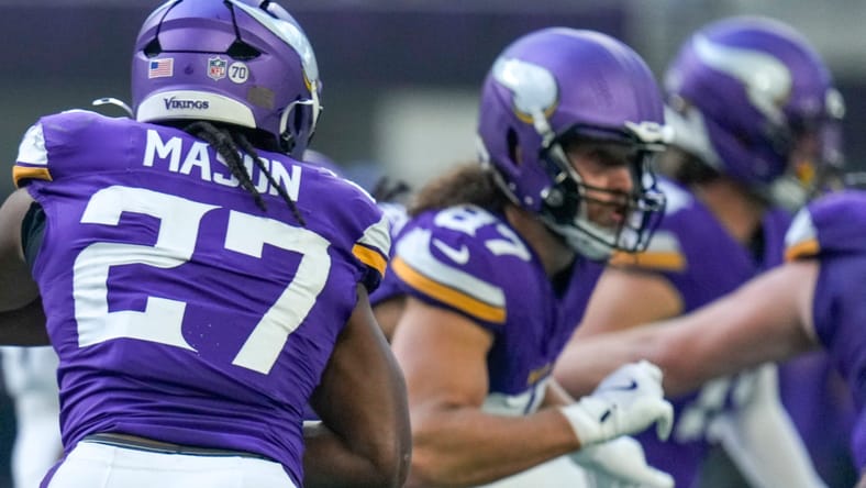 Jordan Mason scrambles to throw during Vikings-Bengals game at U.S. Bank Stadium, 2025.
