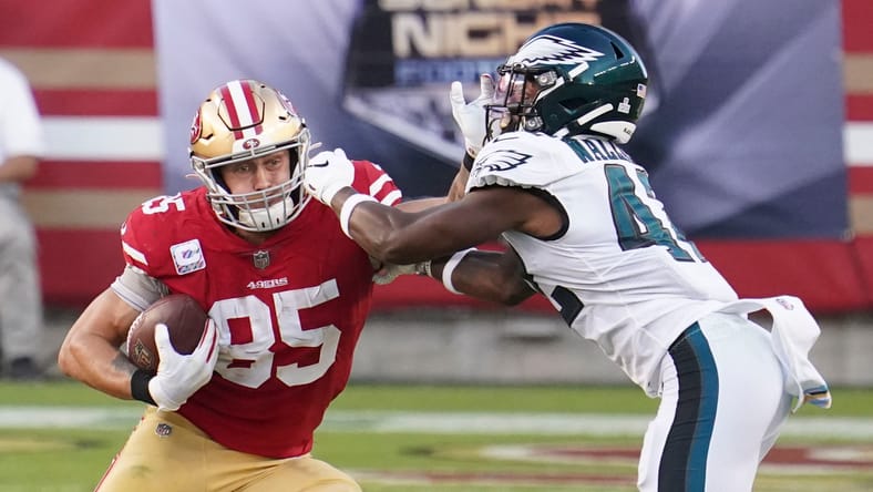 George Kittle runs as K’Von Wallace defends for Eagles. Wallace signed with the Vikings in 2025.