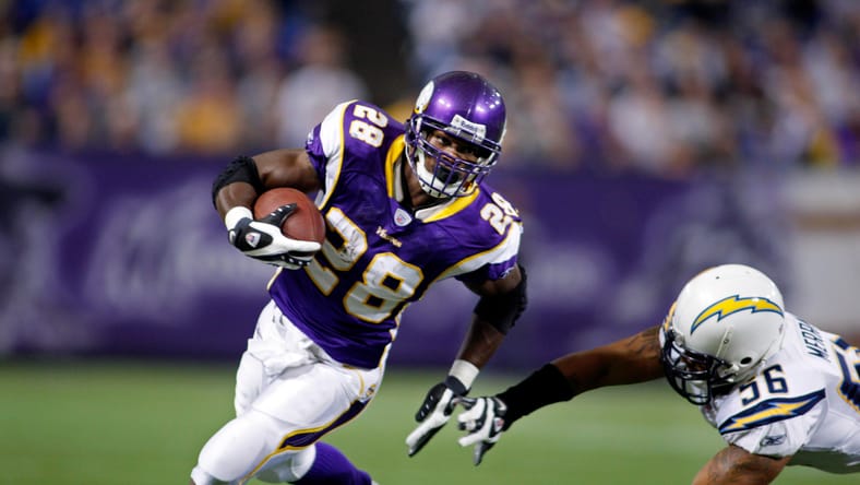 Adrian Peterson runs past Shawne Merriman in 2007 game.