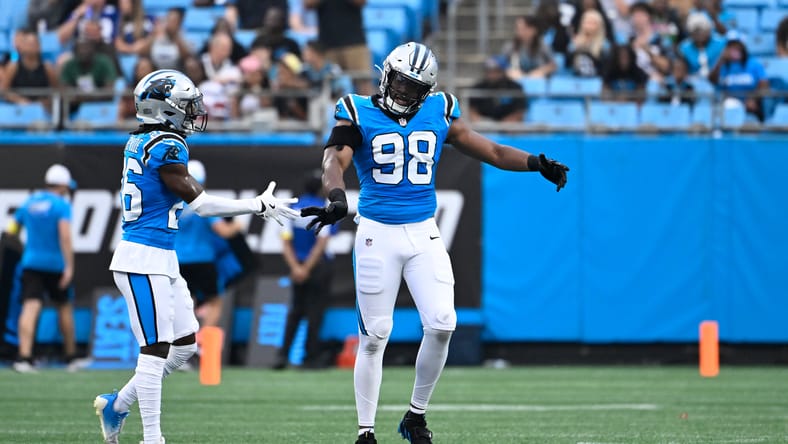 Former Vikings OLB D.J. Wonnum reacts with Chau Smith-Wade during Panthers preseason.