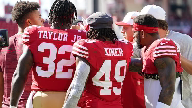 49ers running backs huddle during warmups before Broncos game.