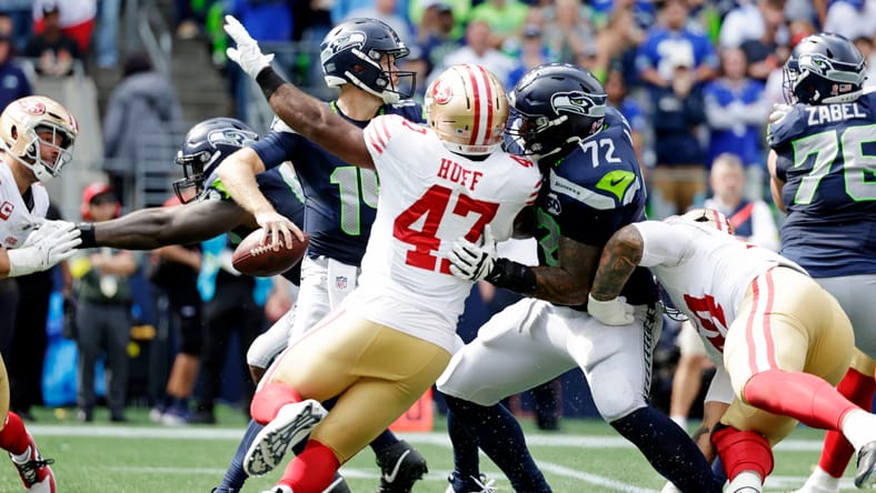 Sam Darnold looks to pass against the 49ers during the first half at Lumen Field.