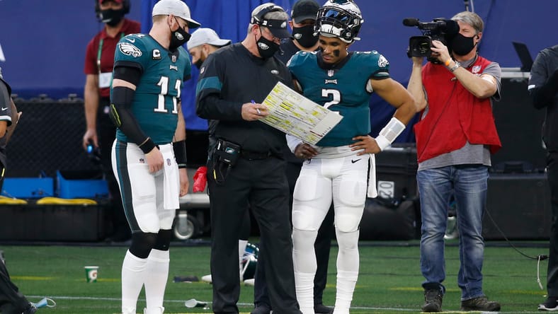 Carson Wentz and Jalen Hurts talk with Doug Pederson during the Eagles-Cowboys game at AT&T Stadium.