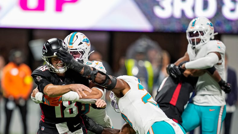 Jaelan Phillips and Jordyn Brooks pressure Kirk Cousins during the first quarter at Mercedes-Benz Stadium.