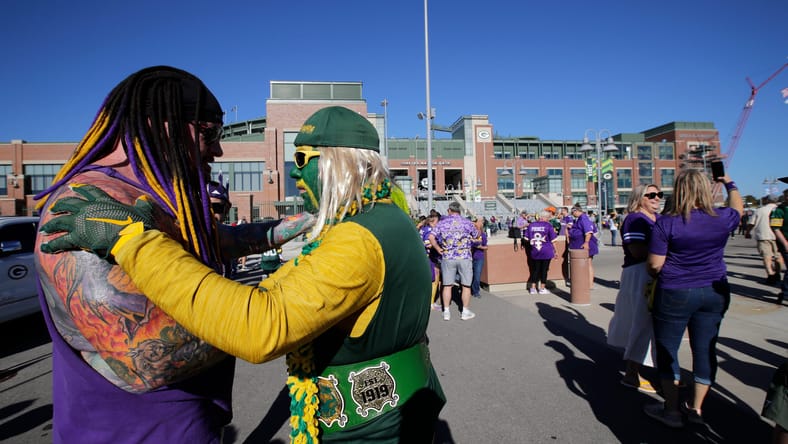 Vikings fan “Sir Death” and a Packers fan chat before kickoff at Lambeau Field.