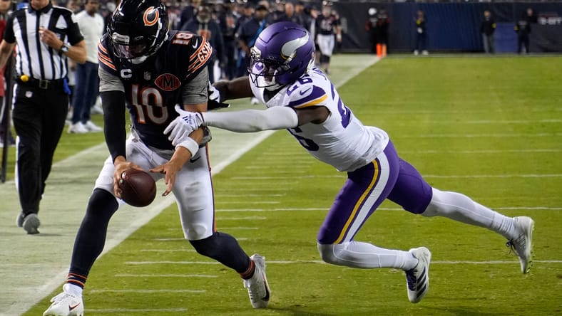 Caleb Williams evades Theo Jackson while running the ball during second-half action at Soldier Field.