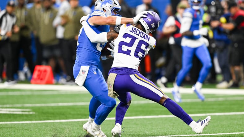 Sam LaPorta stiff-arms Theo Jackson during first-quarter play between the Lions and Vikings at Ford Field.