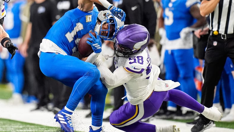 Amon-Ra St. Brown makes a catch with Jonathan Greenard defending at Ford Field.