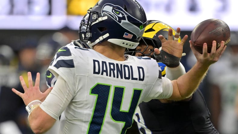Sam Darnold pressured by Jared Verse at SoFi Stadium.