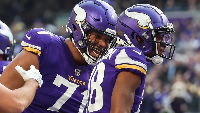 Christian Darrisaw, Justin Jefferson, and K.J. Osborn on the field during a Vikings–Packers game at U.S. Bank Stadium