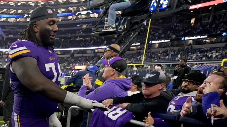 Bo Richter and Donovan Jackson celebrating with Vikings fans after a game at AT&T Stadium. Donovan Jackson Vikings guard.