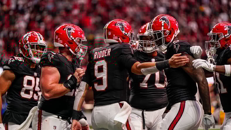 Desmond Ridder celebrates a rushing touchdown with Falcons teammates.