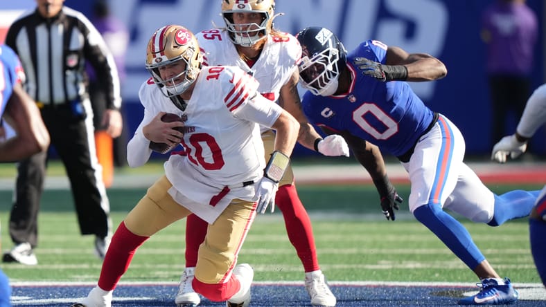 Mac Jones scrambles against the Giants at MetLife Stadium. Jones could be in the Vikings rumor mill in 2026. 