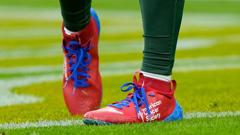 Malik Willis stands on the field before a Packers game at Lambeau Field.