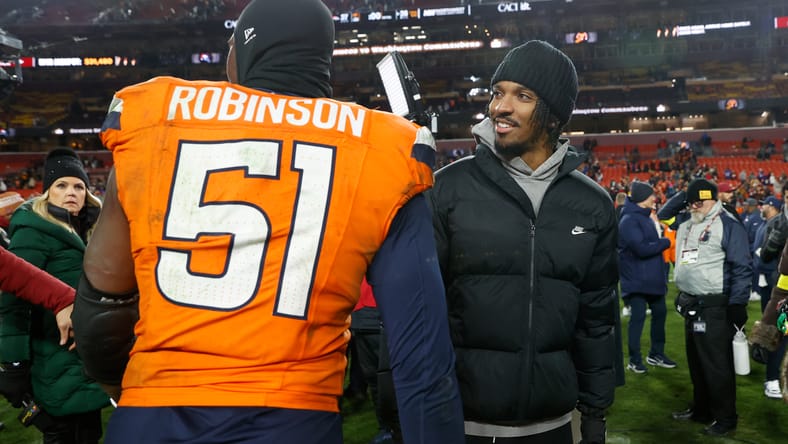 Que Robinson and Jayden Daniels talk at midfield after the matchup.