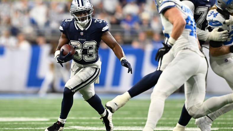 Javonte Williams runs the ball against the Lions at Ford Field.