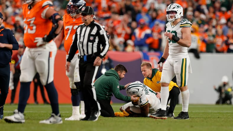 Medical staff treat Micah Parsons on the field after he suffers an injury in Denver.