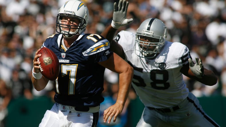 Philip Rivers tries to evade Kalimba Edwards against the Raiders.