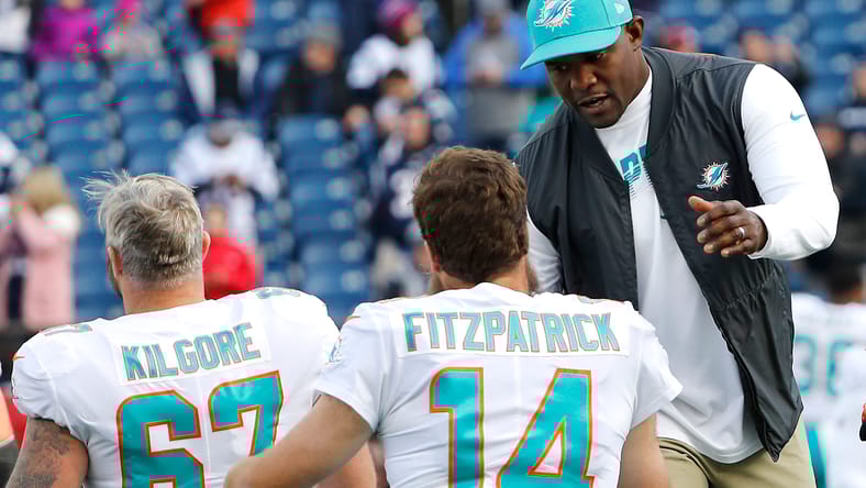 Brian Flores greets Ryan Fitzpatrick before a Dolphins game.