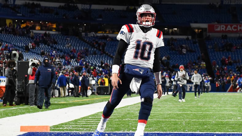 Mac Jones reacts before a Patriots-Bills game at snowy Highmark Stadium. Vikings quarterback options 2026.