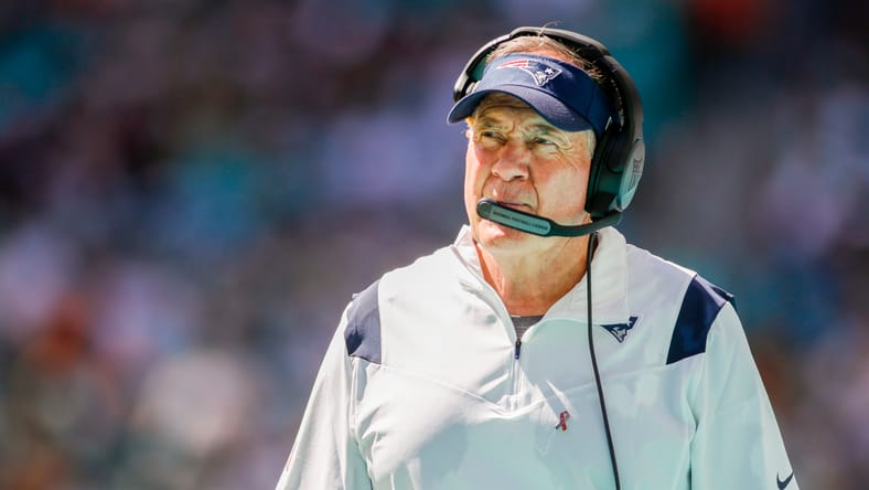 Bill Belichick standing on the Patriots sideline during a Dolphins game.