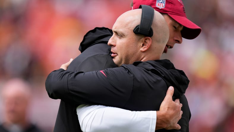 Jonathan Gannon hugs Drew Petzing before a Cardinals game.