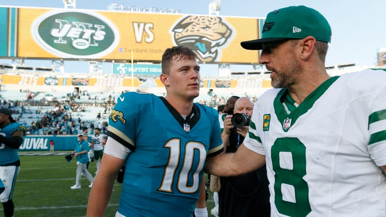 Mac Jones and Aaron Rodgers standing on the field after a Jaguars-Jets game.
