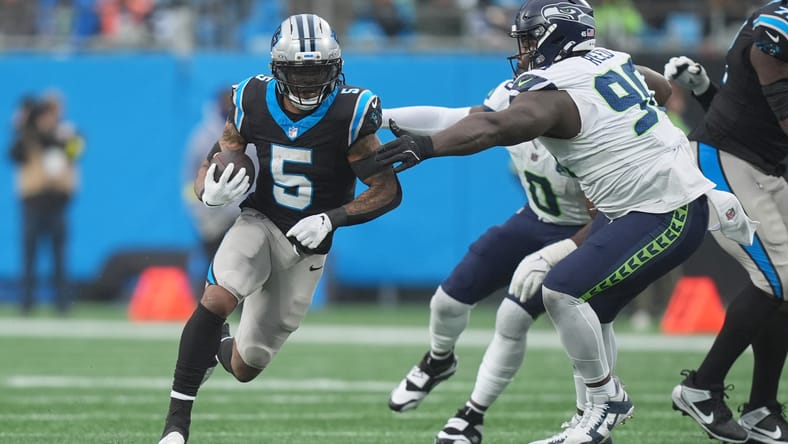 Rico Dowdle running against Seahawks defender Jarran Reed during third quarter in Charlotte.