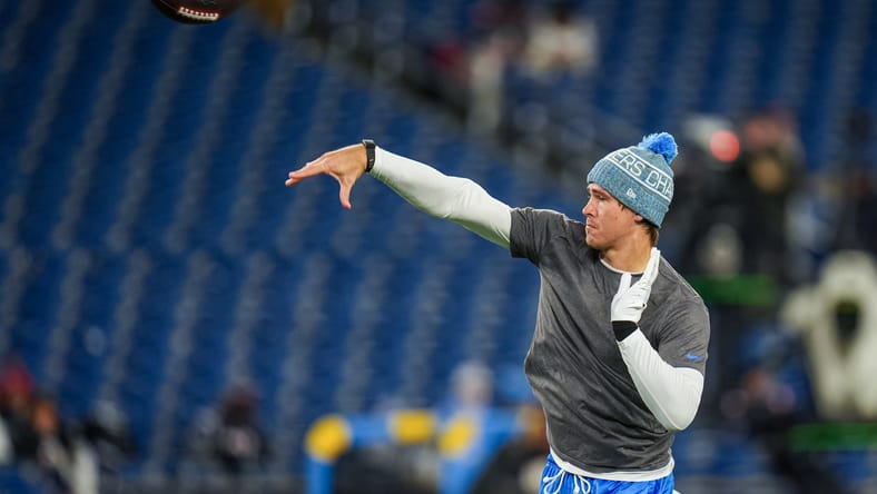 Justin Herbert warms up before a playoff game at Gillette Stadium.