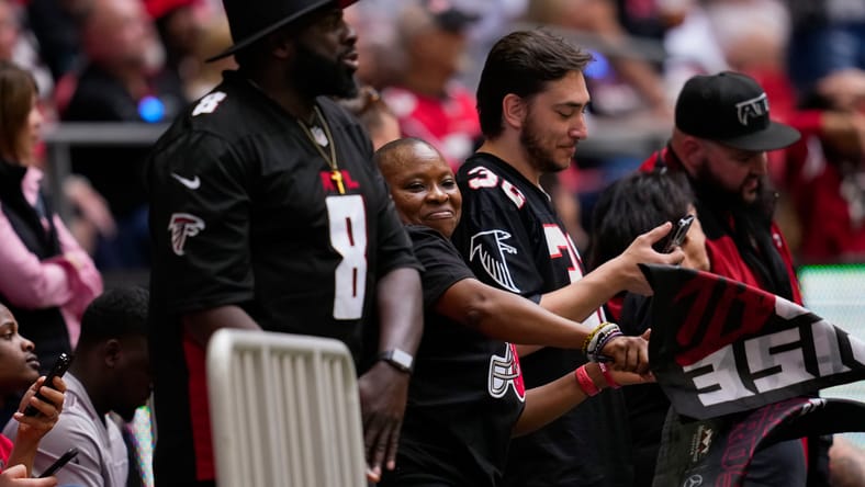 Falcons fans in 2022 at Mercedes-Benz Stadium, one wearing a Kyle Pitts jersey