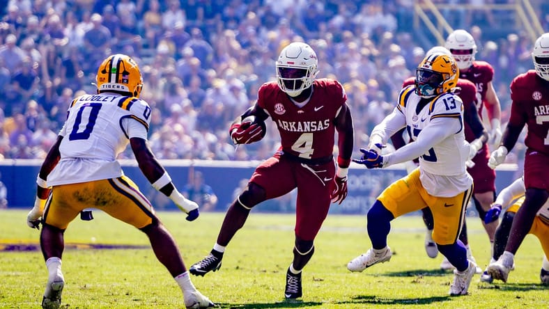 Arkansas running back Mike Washington carries the ball while LSU safety Tamarcus Cooley moves in to tackle.