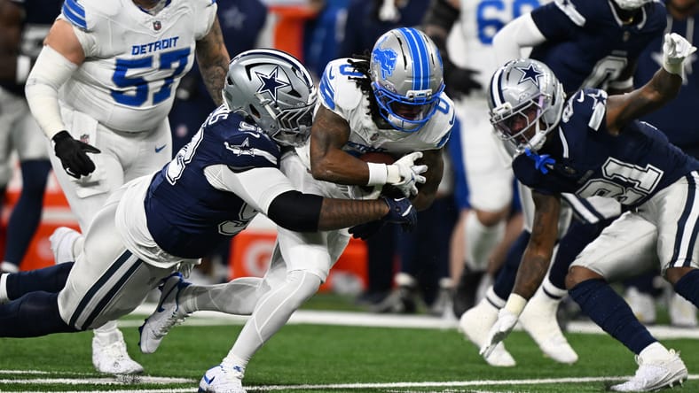 Jahmyr Gibbs tackled by Quinnen Williams at Ford Field.