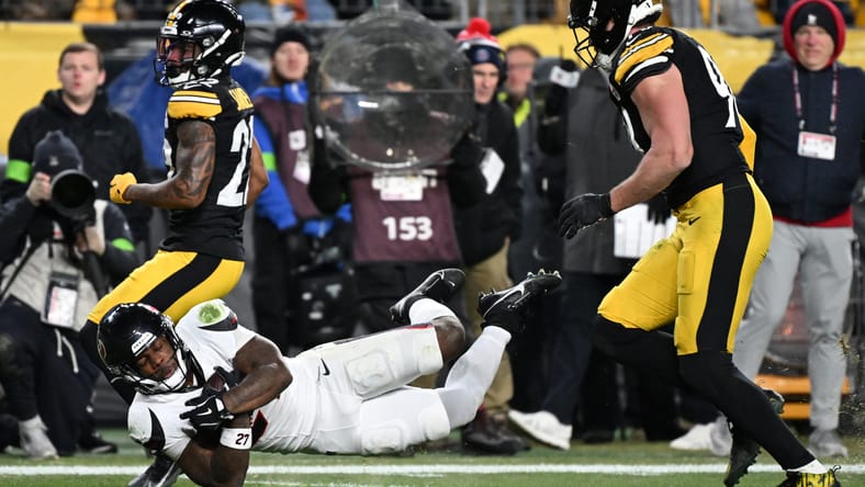 Woody Marks diving between Asante Samuel Jr. and T.J. Watt in a playoff game.