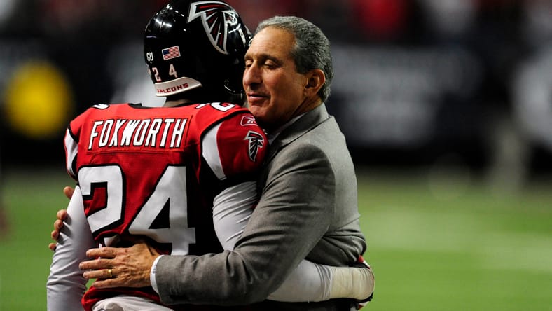 Arthur Blank hugging Domonique Foxworth after a play. Domonique Foxworth Vikings QB solution.