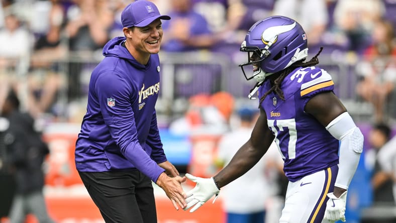 Kevin O'Connell speaks with Vikings cornerback Tavierre Thomas on the sideline before a preseason game against the Houston Texans.
