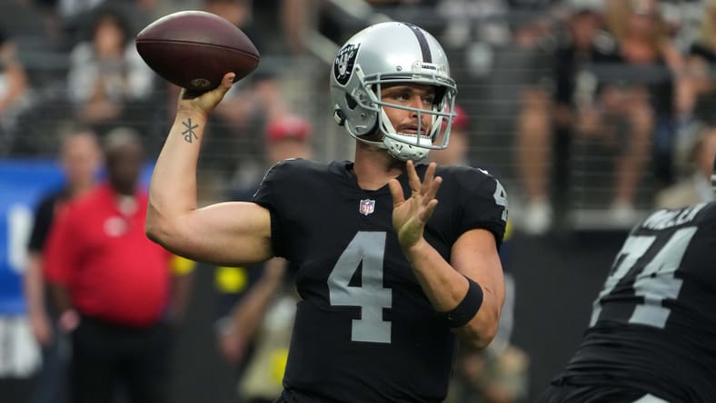 Derek Carr throwing a pass during a Raiders game against the Arizona Cardinals at Allegiant Stadium.