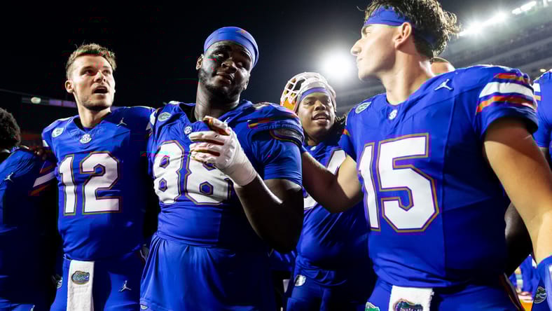 Florida players Micah Leon, Caleb Banks, and Graham Mertz celebrating after a win over Tennessee.