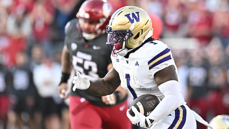 Jonah Coleman runs the ball during Apple Cup game. Vikings running back