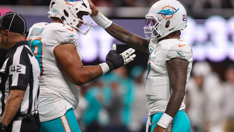 Dolphins quarterback Tua Tagovailoa celebrates a touchdown with teammate Larry Borom. Vikings free agents