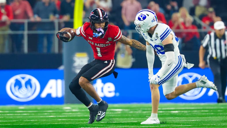 Reggie Virgil runs with the ball as a BYU defender pursues during a game. Vikings mock draft