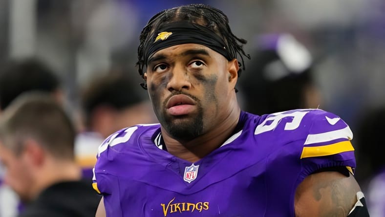 Washington Commanders quarterback Jayden Daniels avoids a tackle from Vikings defensive end Jonathan Allen at U.S. Bank Stadium.