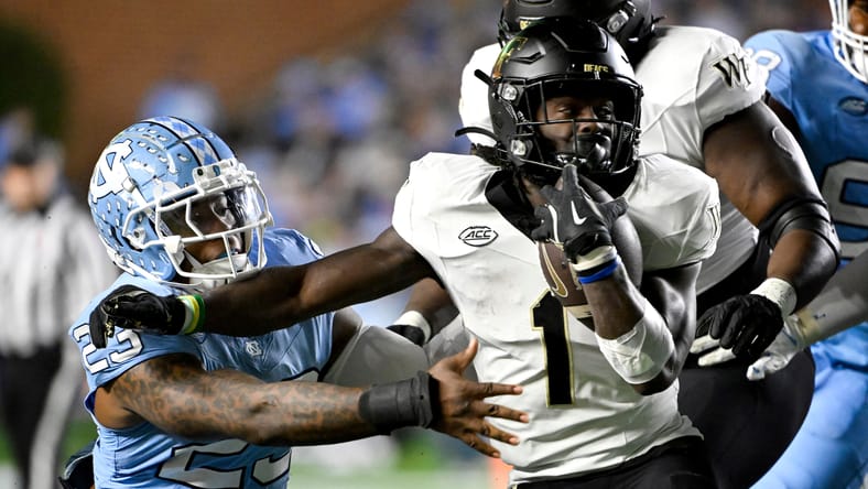 Demond Claiborne runs the ball as Power Echols defends during a game at Kenan Memorial Stadium. Demond Claiborne Vikings
